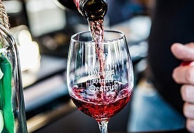 Roter Wein wird in ein Weinglas ausgeschenkt